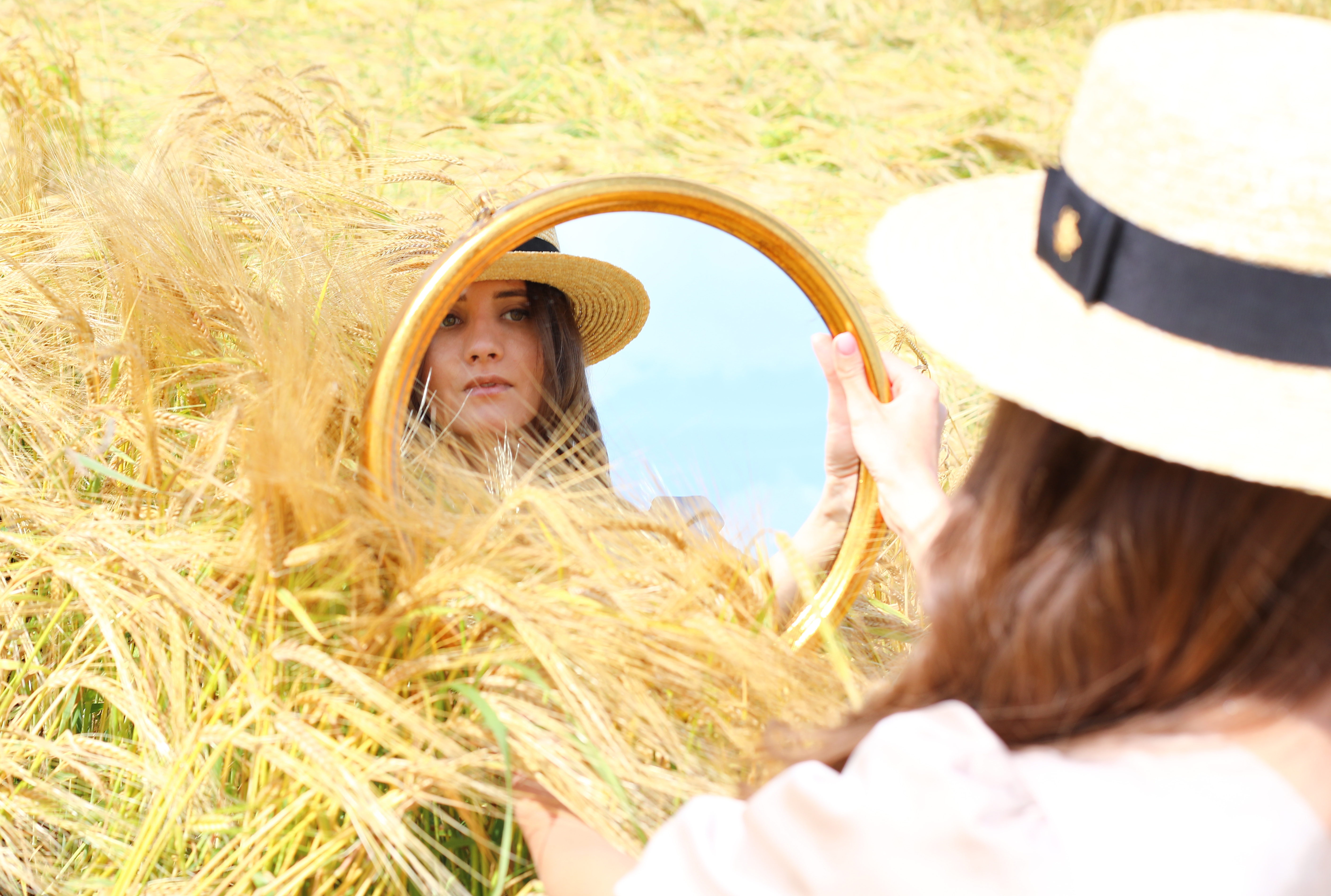 girl looking in mirror in field